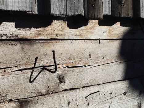 bent nail into a wooden wall