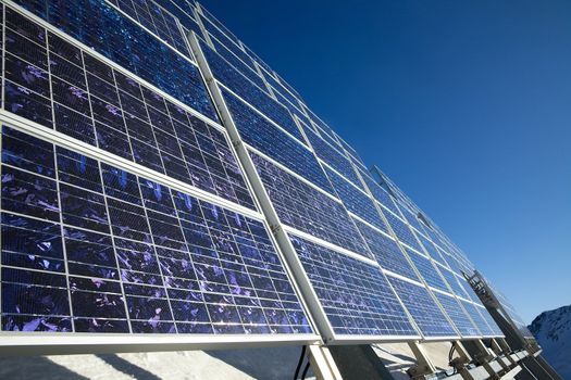 Big cluster of solar panels on a mountain peak