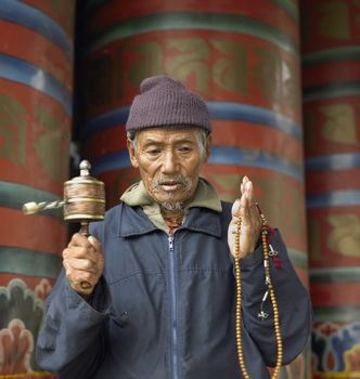 A Bhutanese man with prayer wheel in Paro Dzong in the Kingdom of Bhutan.