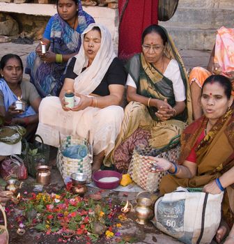Group of Hindu women at prayer on the Hindu ghats on the banks of the Holy River Ganges (Ganga) in Varanasi (Benares) in the Uttar Pradesh region of northern India.