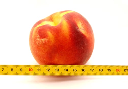 Peach and ruler on a white background    