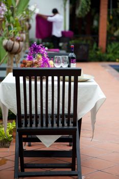 Restaurant table with by the pool and a waiter in the background working