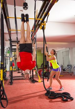 Crossfit fitness dip ring man workout upside down at gym dipping ans woman with rope