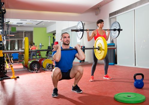 Crossfit fitness gym weight lifting bar by woman and man group workout