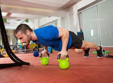 Crossfit fitness man push ups Kettlebells pushup exercise at gym workout