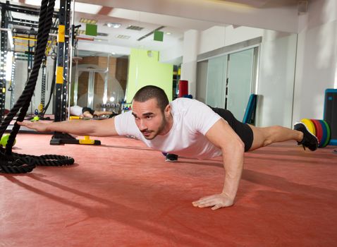 Crossfit fitness man balance push ups with one leg and arm up exercise at gym workout