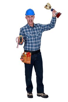 Man with a voltmeter and a trophy in hand