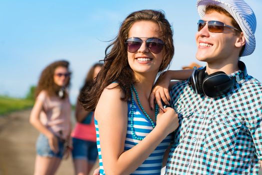 young couple standing on the road, having fun with friends