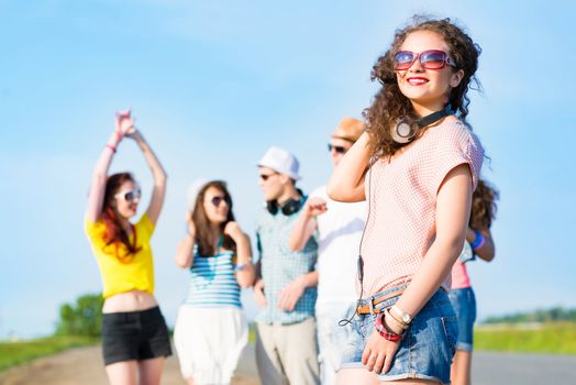 young woman with headphones on a background of blue sky and funny friends