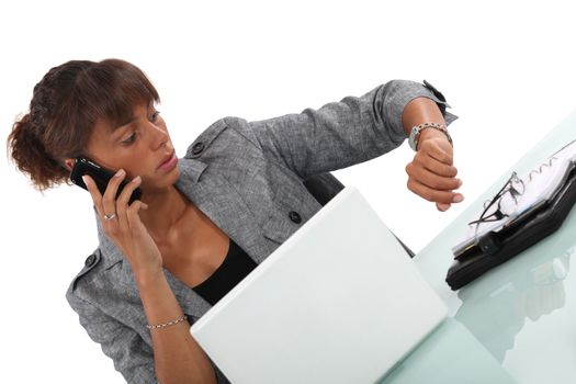 businesswoman talking on her cell and looking at her watch