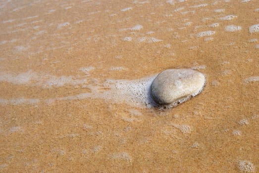 Close-up of a stone on the sandy beach