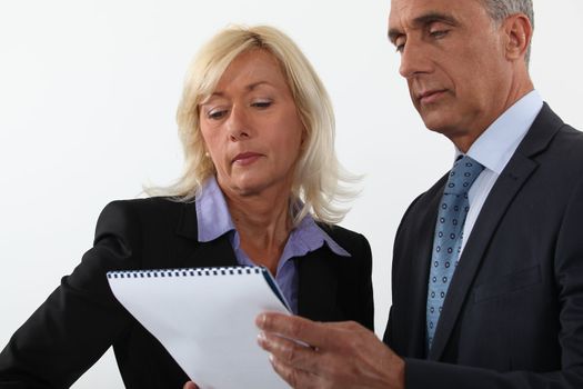 Mature business couple looking at a document