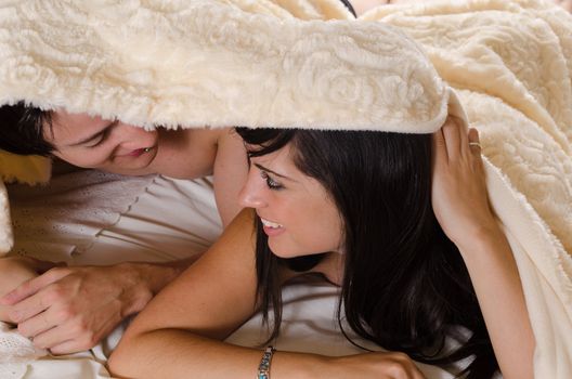 Young couple enjoying some intimacy under a blanket