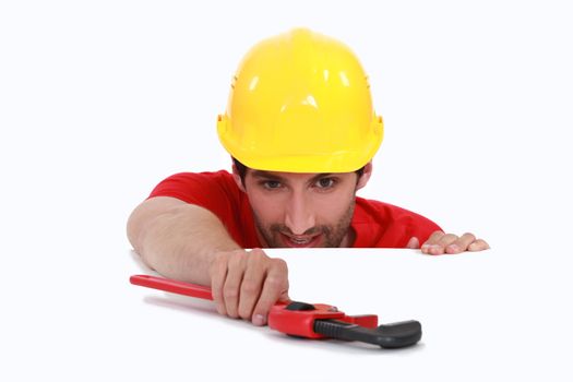 Manual worker resting wrench on white surface