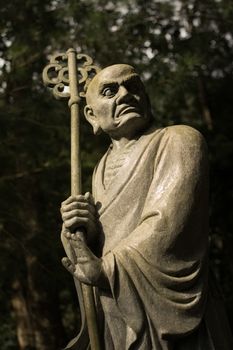 Old ruined Arhat Kanakbharadvaja statue in forest, Taiwan, Asia.