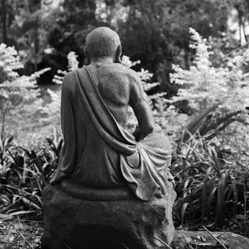 Old ruined Arhat Kanakbharadvaja statue. Black and white photo.