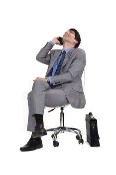 Man sitting in a chair by phone