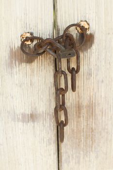 Old door with rusty lock and chain, closeup