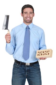 Man holding a brick and a trowel