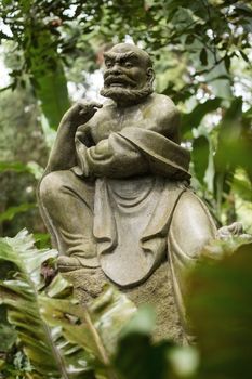 Old ruined Arhat Kanakbharadvaja statue in forest, Taiwan, Asia.