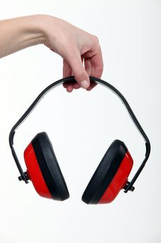 Hand holding a pair of ear defenders