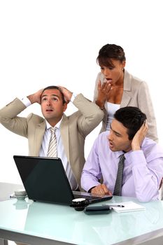 Three shocked business people looking at results