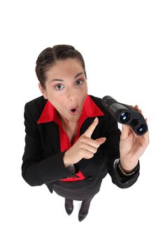 Shocked businesswoman looking through binoculars