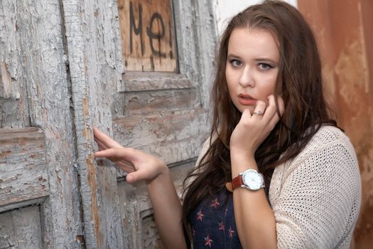 Beautiful plus size woman expresses delight against an old door