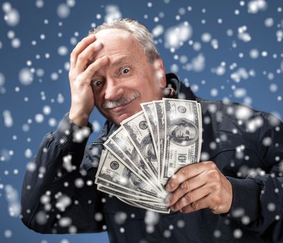 christmas, x-mas, sale, banking concept - Lucky old man holding group of dollar bills. Focus on money