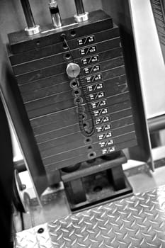 Black and white image of the weight or resistance selector on professional exercise equipment at a commercial gym