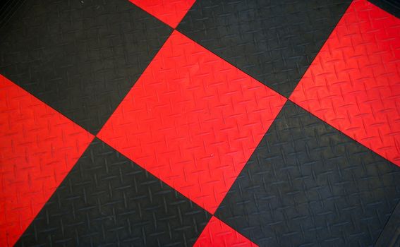 Black and red non-slip rubber mat with herringbone pattern arranged as a checker board.