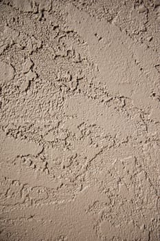 Wall of a home constructed with a brown stucco exterior finish