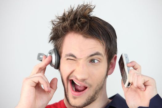 Man holding headphones and mobile telephone