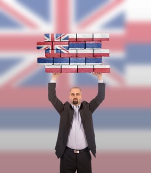 Businessman holding a large piece of a brick wall, flag of Hawaii, isolated on national flag