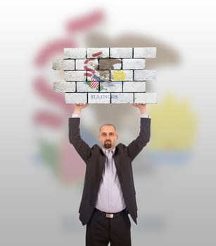 Businessman holding a large piece of a brick wall, flag of Illinois, isolated on national flag