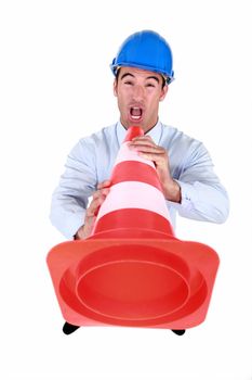 Man shouting into traffic cone