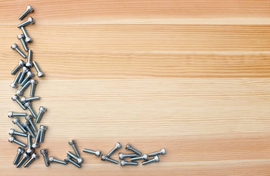 Socket head bolts as L-shape border on woodgrain background