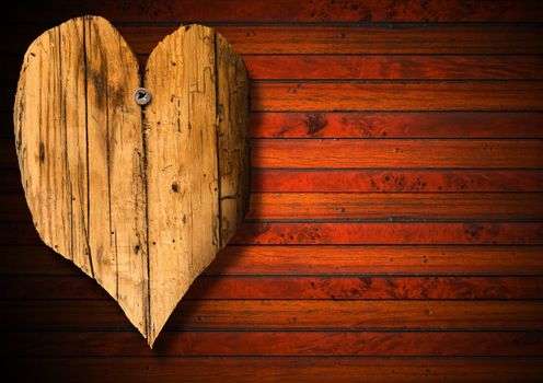 Handmade wooden heart hanging on brown wooden background