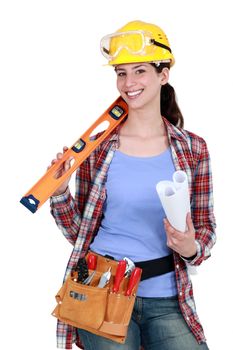 Female construction worker holding tools and a rolled-up plan