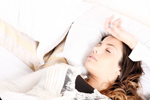 A woman lying alone on the bed.
