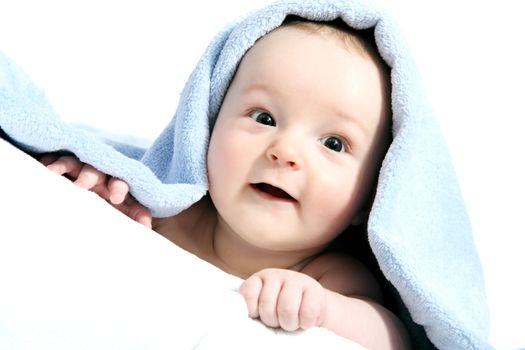 happy baby after bath under a blanket