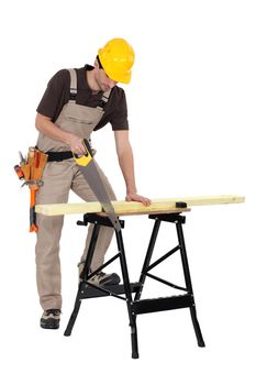 Joiner sawing a plank, studio shot