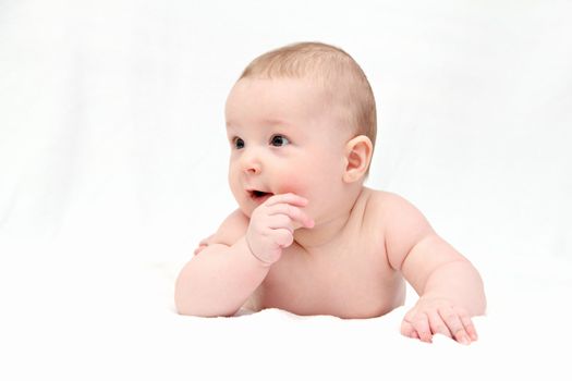 Beautiful happy baby lies on white blanket