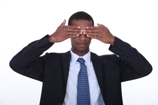 Black man covering his eyes