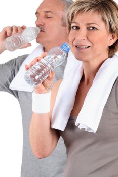 couple senior drinking water after training