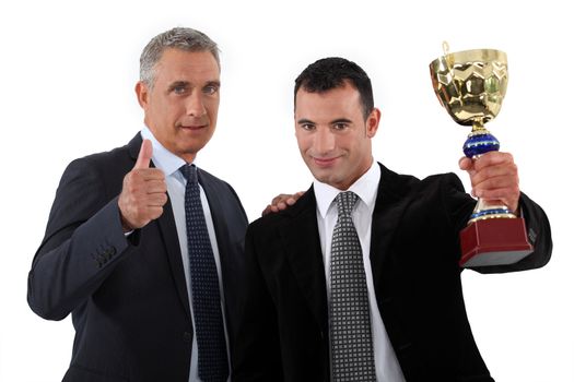 Two businessmen holding trophy