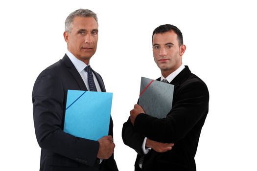 Two businessmen standing and holding files.