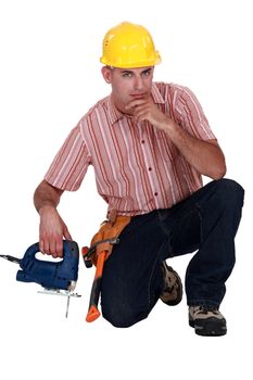 Confident worker kneeling with band saw