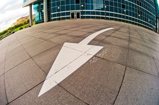 Arrow road markings in the parking lot near the business center.