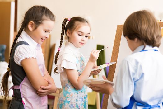 children draw pictures of easels, drawing lesson